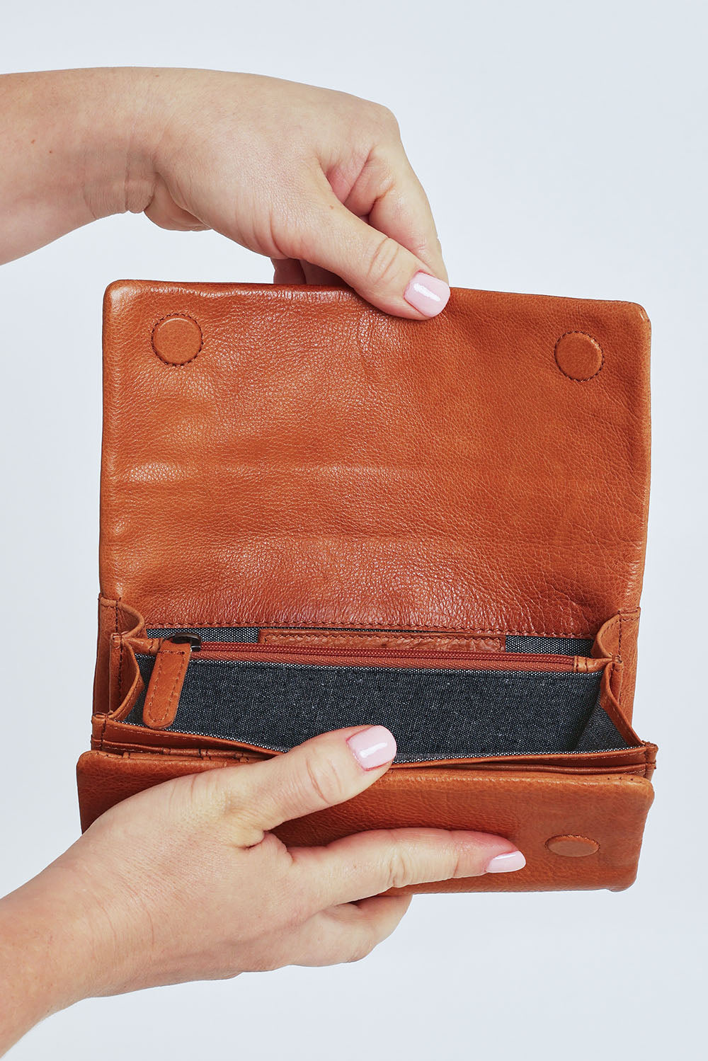 Model Steph wearing size OneSize of the Rose Leather Purse in colour Tan, from the front, cropped image