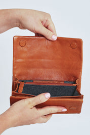 Model Steph wearing size OneSize of the Rose Leather Purse in colour Tan, from the front, cropped image