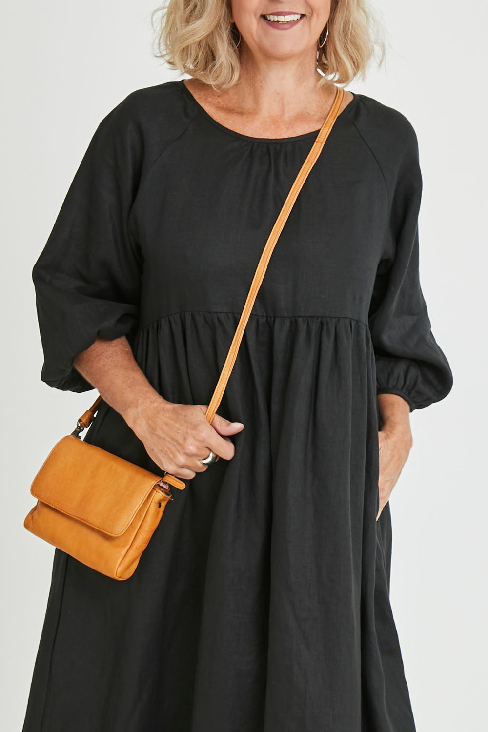 Model Sandy wearing size OneSize of the Sara Leather Bag in colour Tan, from the front, cropped image