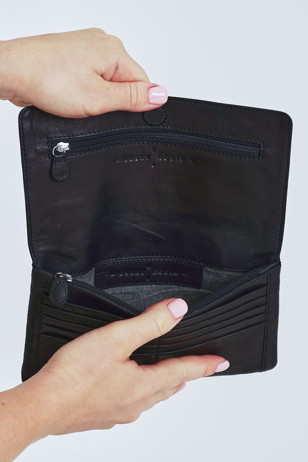 Model Steph wearing size OneSize of the Sirena Leather Purse in colour Black (Black), from the front, cropped image