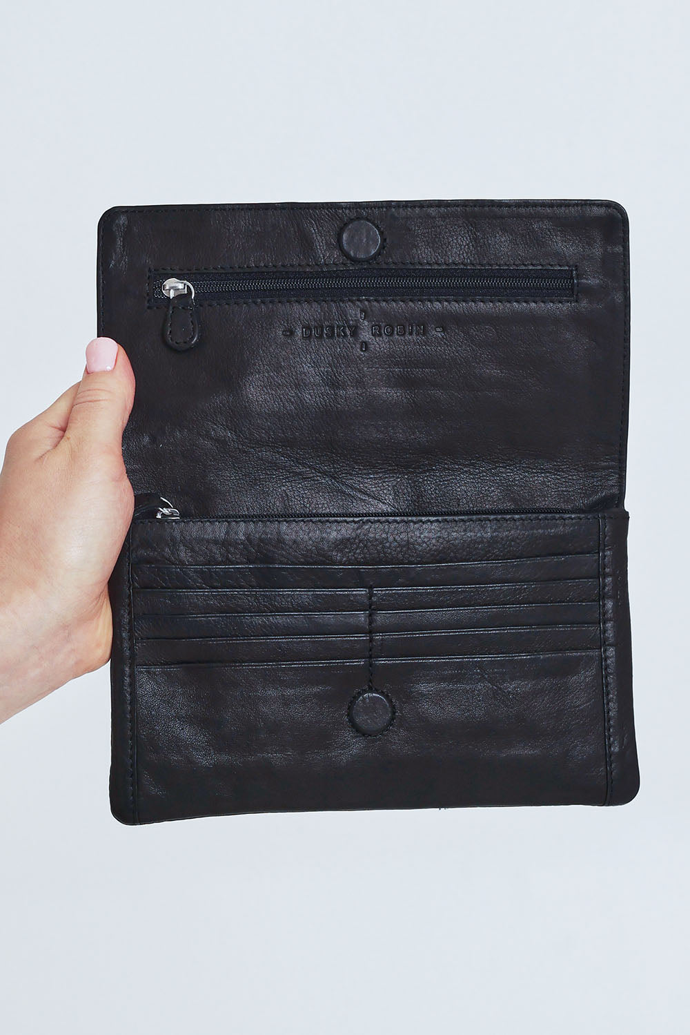 Model Steph wearing size OneSize of the Sirena Leather Purse in colour Black (Black), from the front, cropped image