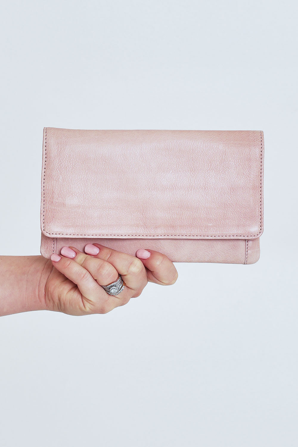 Model Steph wearing size OneSize of the Sirena Leather Purse in colour Duskypink (Pink), from the front, cropped image