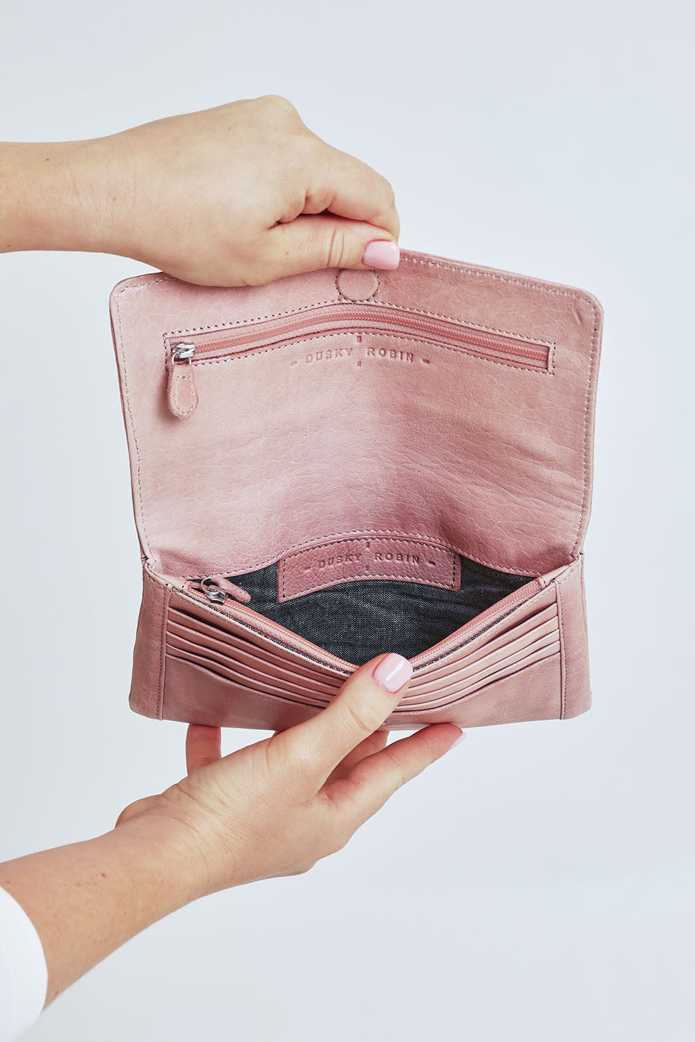Model Steph wearing size OneSize of the Sirena Leather Purse in colour Duskypink (Pink), from the front, cropped image