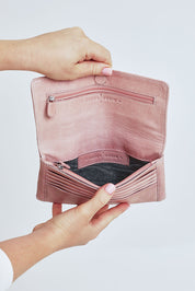 Model Steph wearing size OneSize of the Sirena Leather Purse in colour Duskypink (Pink), from the front, cropped image