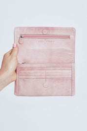 Model Steph wearing size OneSize of the Sirena Leather Purse in colour Duskypink (Pink), from the front, cropped image