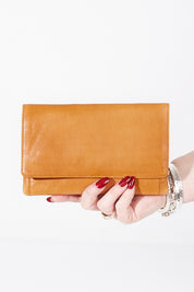 A model wearing the Sirena Leather Purse in colour Tan, from the front, showing the whole outfit