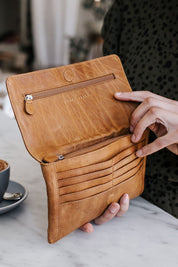 A model wearing the Sirena Leather Purse in colour Tan, from the front, showing the whole outfit