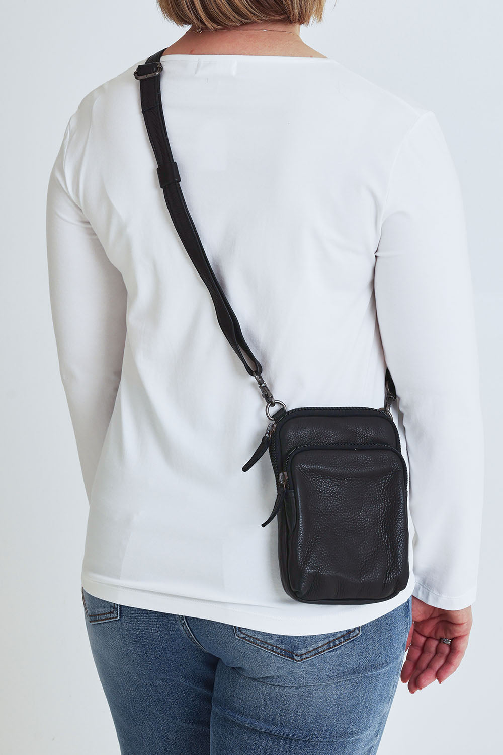 Model Steph wearing the Sophie Small Leather Bag in colour Black (Black), from the back