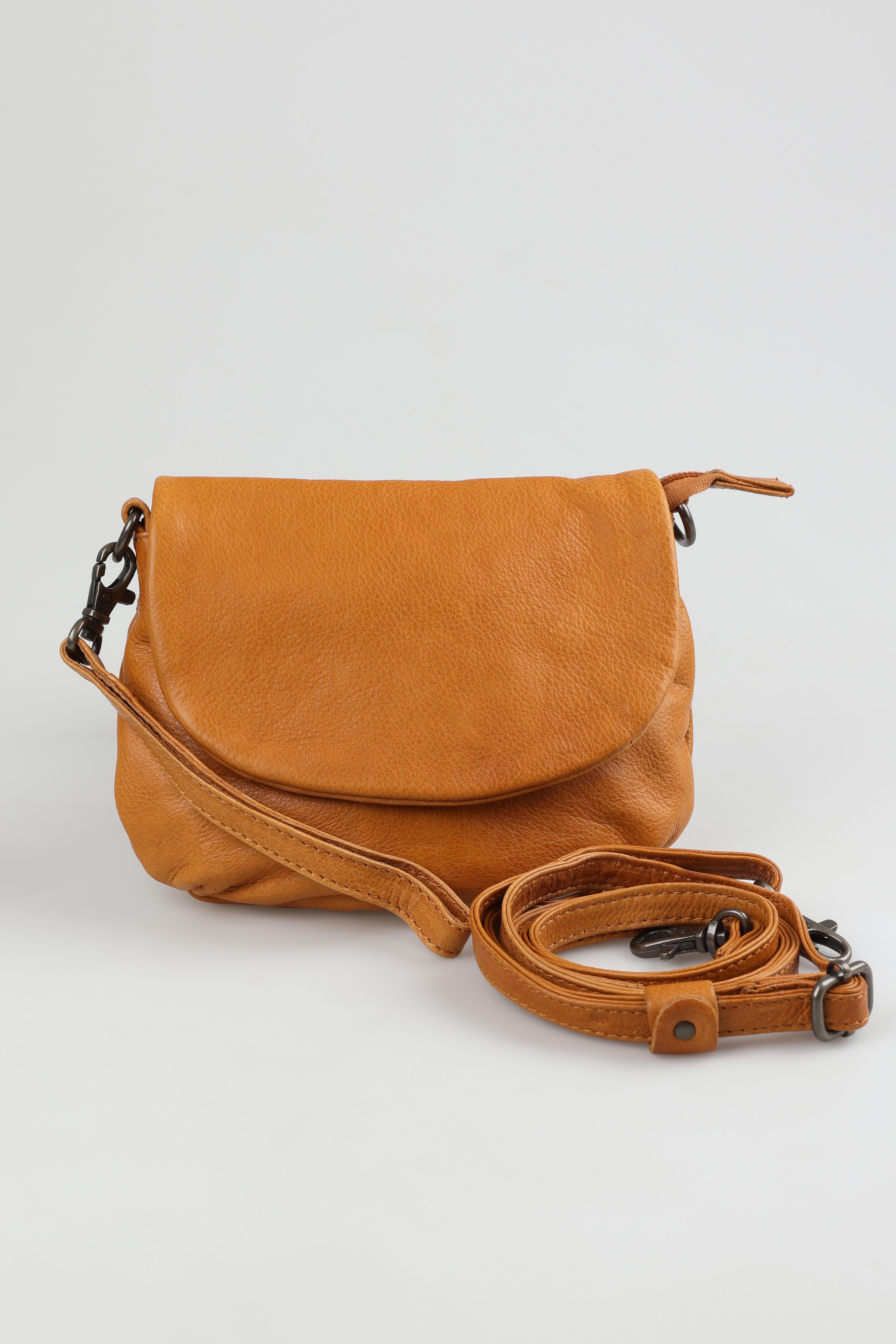A model wearing the Zoe Leather Clutch Bag in colour Tan, from the front, showing the whole outfit