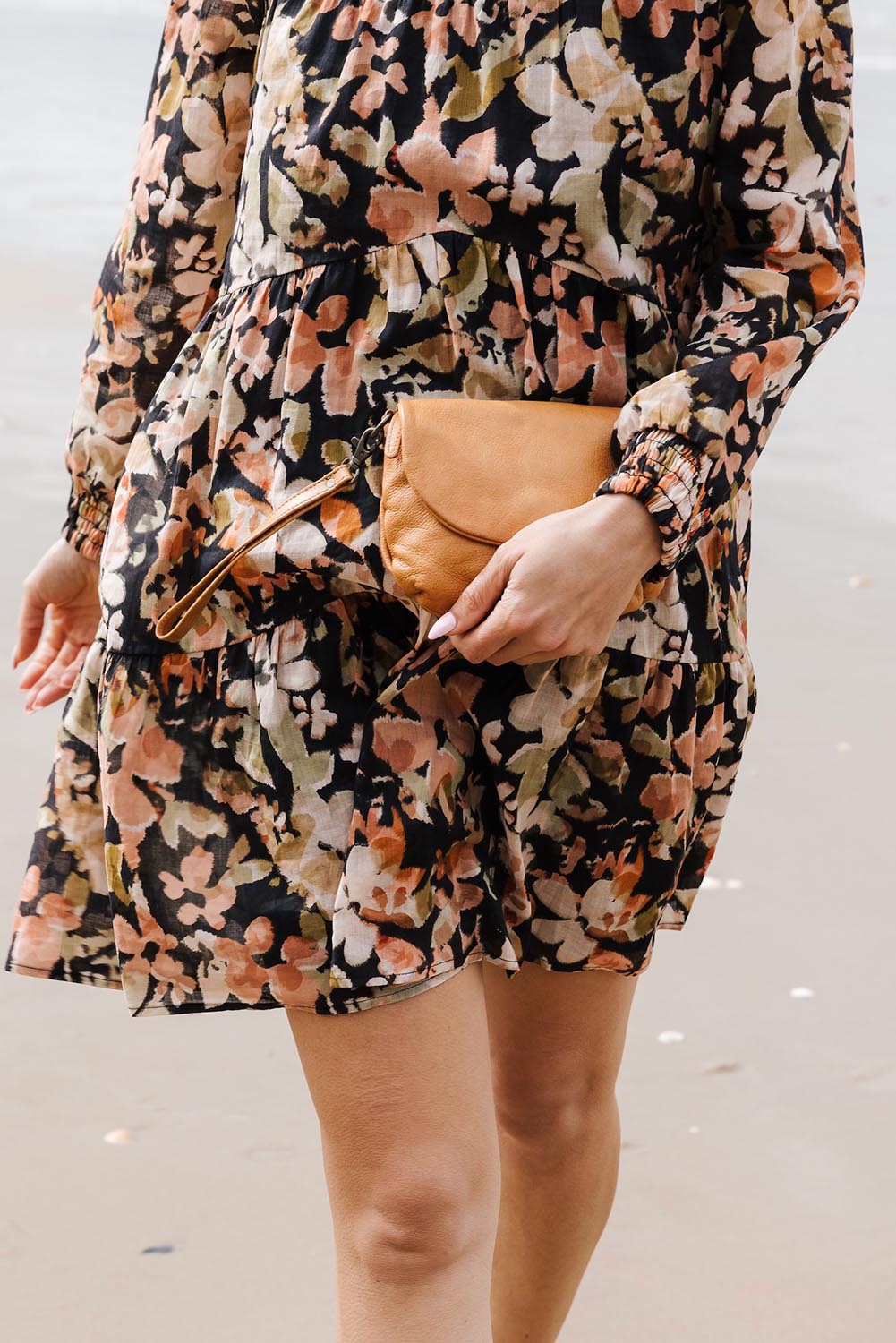A model wearing the Zoe Leather Clutch Bag in colour Tan, from the front, showing the whole outfit