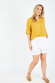 Model Jess wearing size L of the Masai Shorts in colour Salt (White), from the front, showing the whole outfit