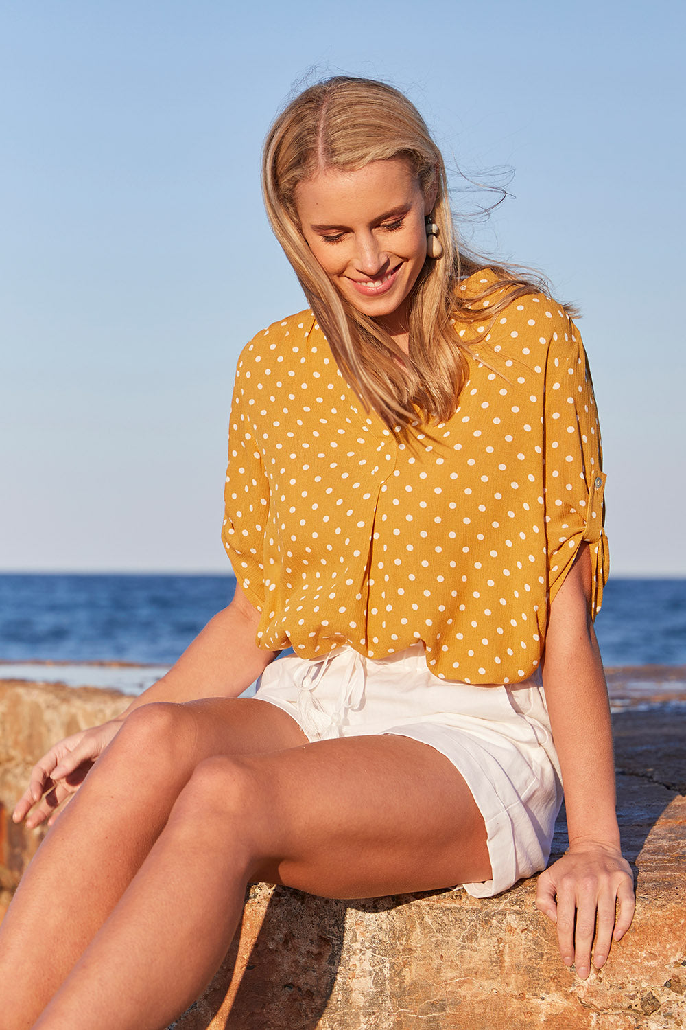 Model Maddy wearing size S of the Masai Shorts in colour Salt (White), from the front, showing the whole outfit