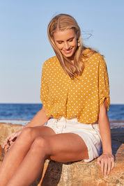 Model Maddy wearing size S of the Masai Shorts in colour Salt (White), from the front, showing the whole outfit
