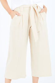 Model Hayley wearing size S of the Manyara Culotte in colour Clay, from the front, cropped image