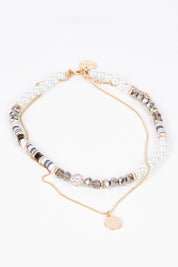 A model wearing size OneSize of the Qualia Beaded Necklace in colour Pebble, from the front, showing the whole outfit