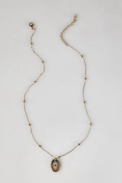 A model wearing the Heritage Necklace in colour Goldshine (Metallics), from the front, showing the whole outfit