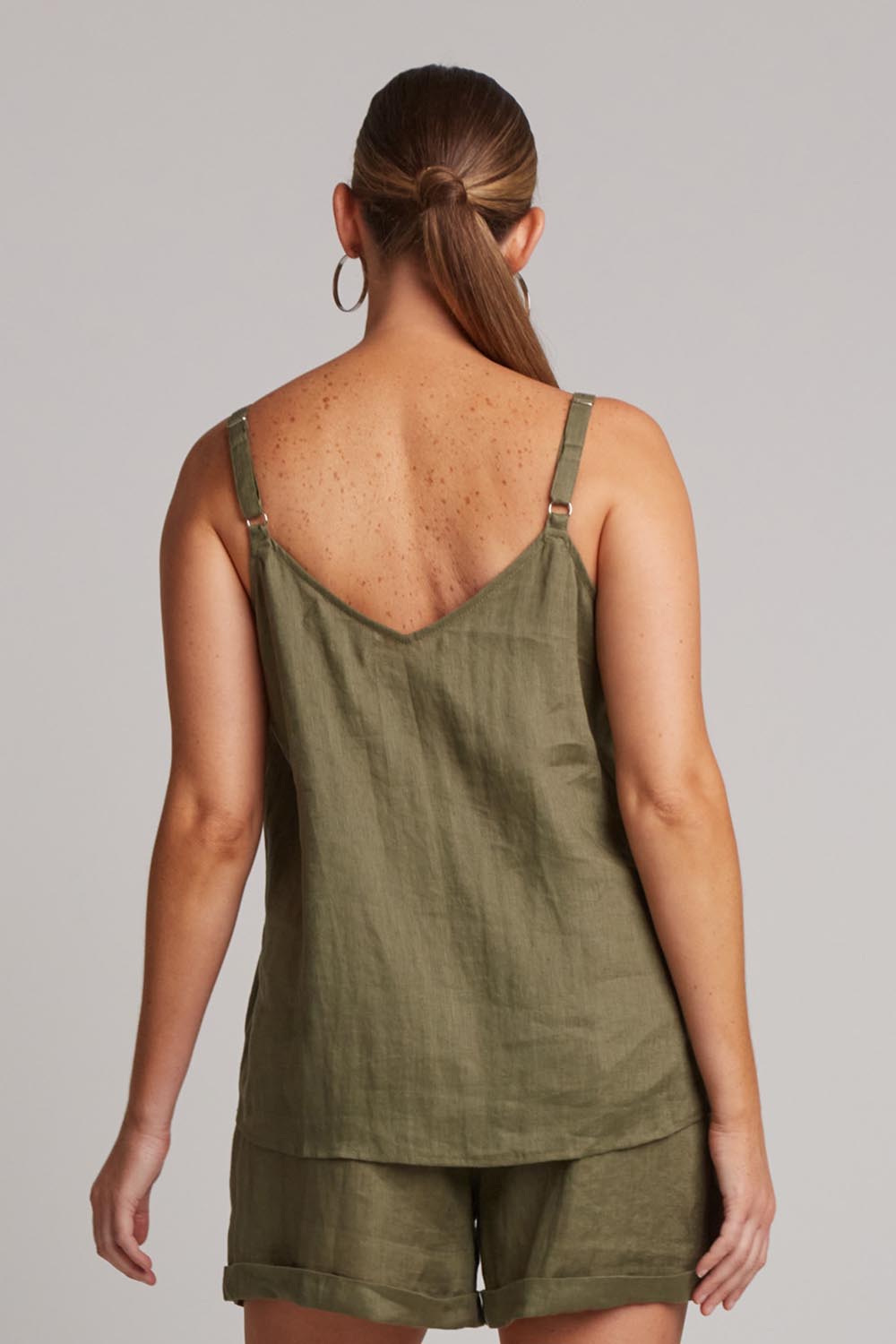 A model wearing the Studio Linen Tank in colour Khaki (Green), from the back