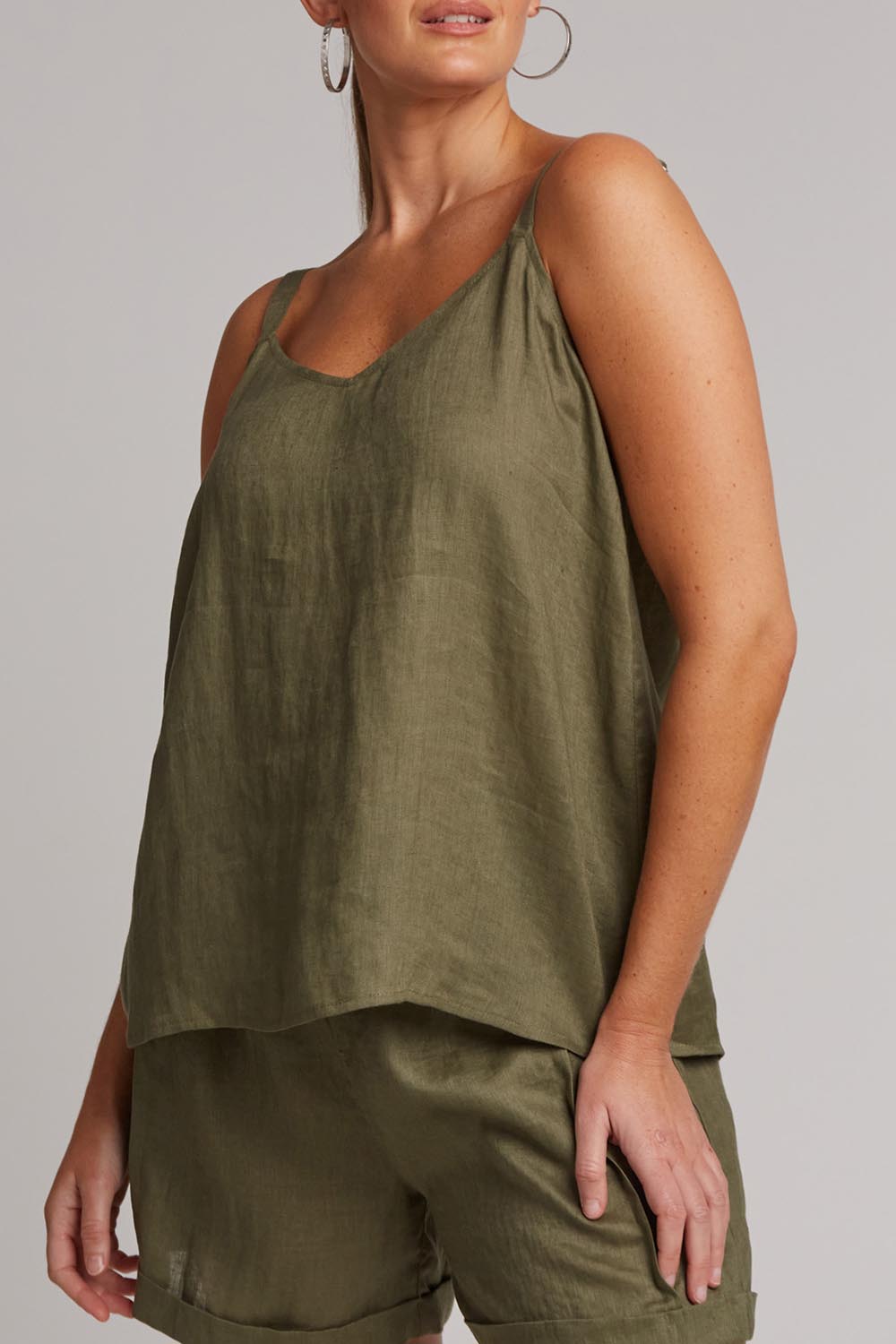 A model wearing the Studio Linen Tank in colour Khaki (Green), from the front, cropped image