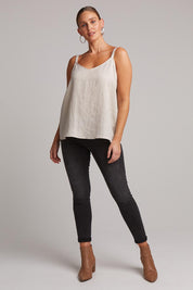 A model wearing the Studio Linen Tank in colour Tusk, from the front, showing the whole outfit