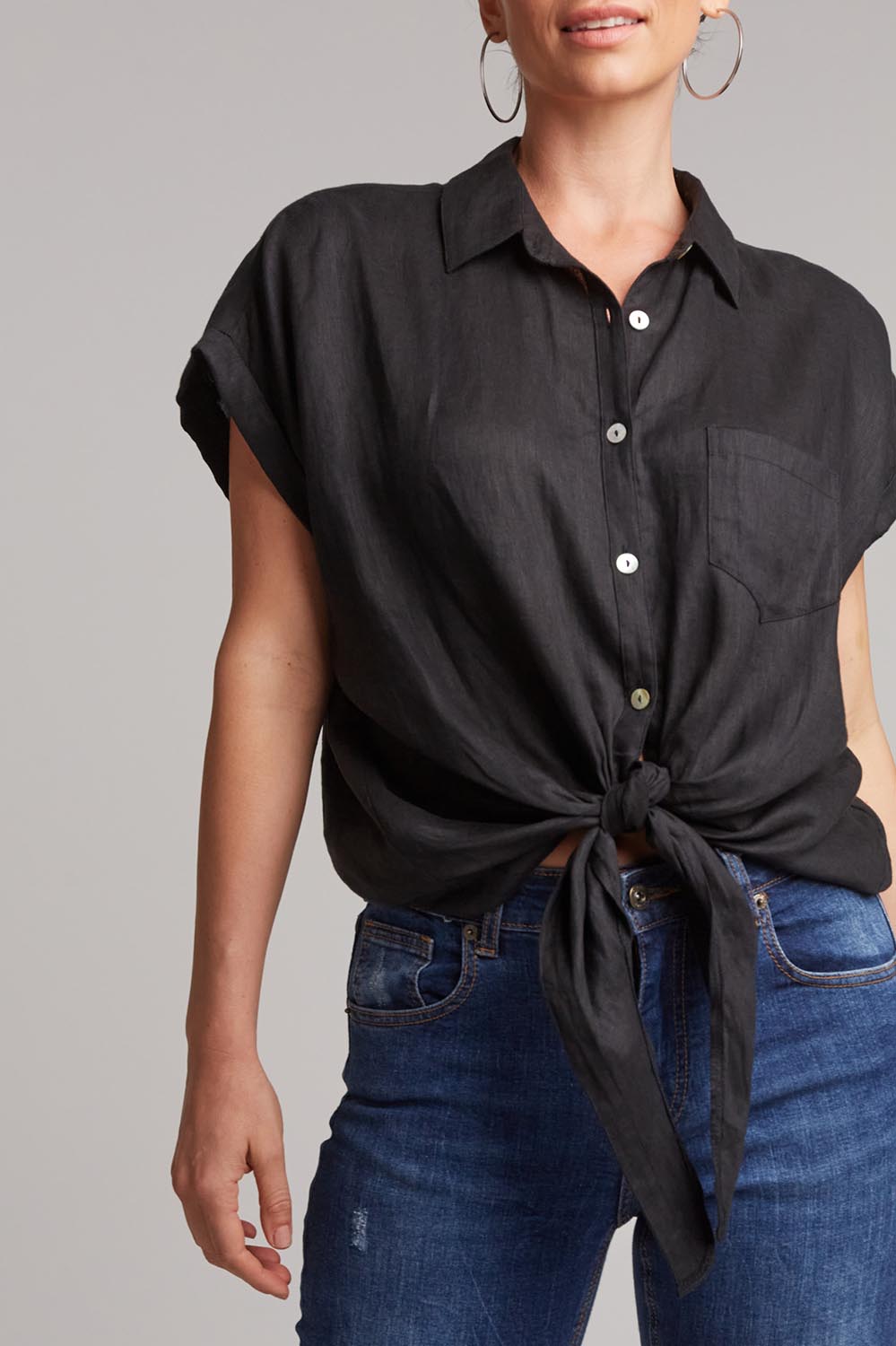 A model wearing the Studio Linen Tie Shirt in colour Ebony (Black), from the front, cropped image