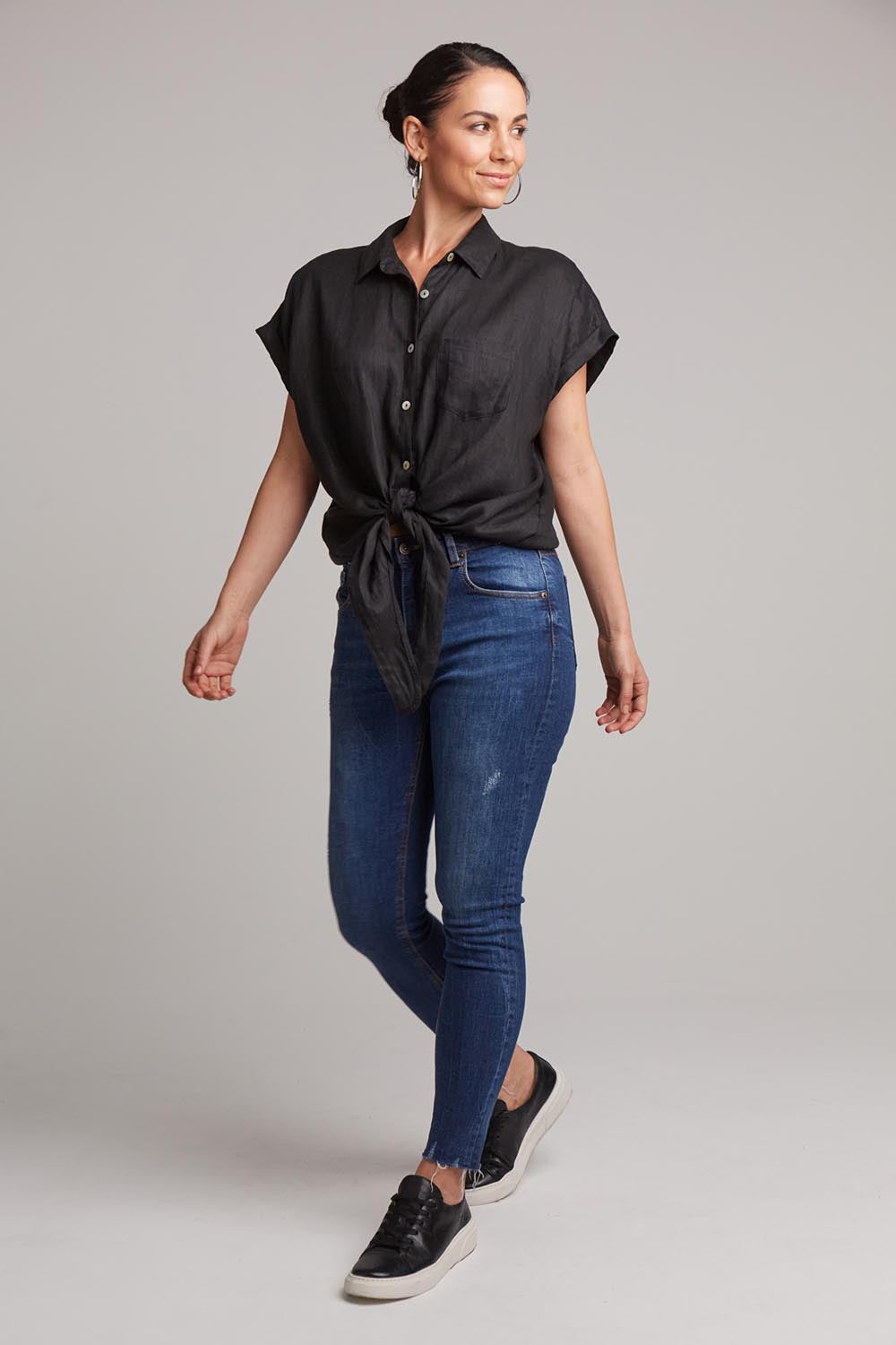 A model wearing the Studio Linen Tie Shirt in colour Ebony (Black), from the front, showing the whole outfit