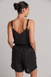 A model wearing the Studio Linen Short in colour Ebony (Black), from the back