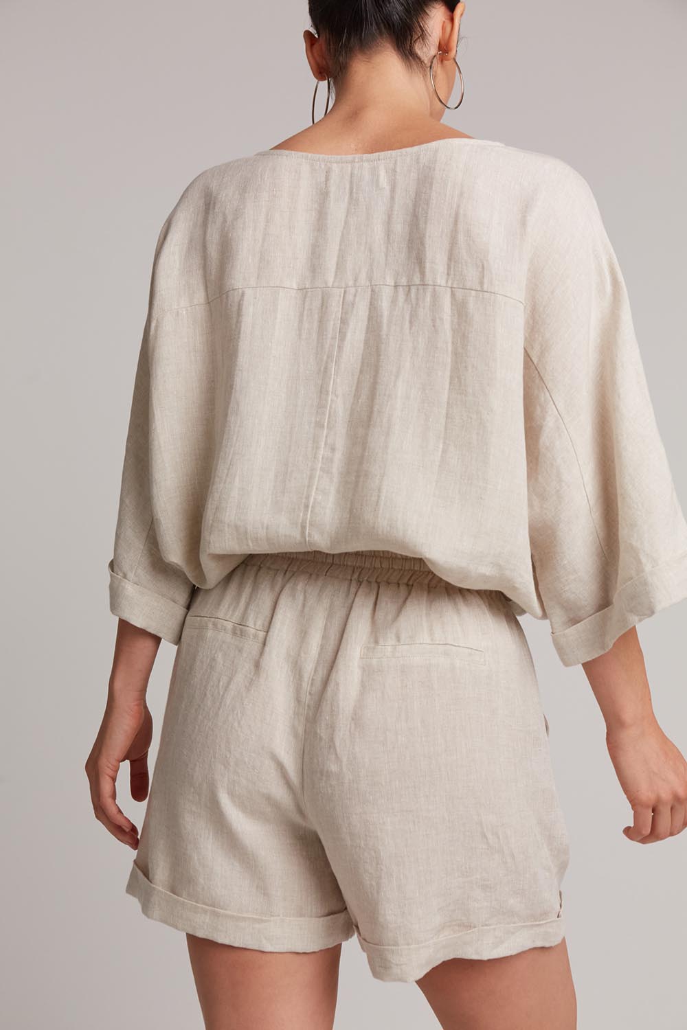 A model wearing the Studio Linen Short in colour Tusk, from the back