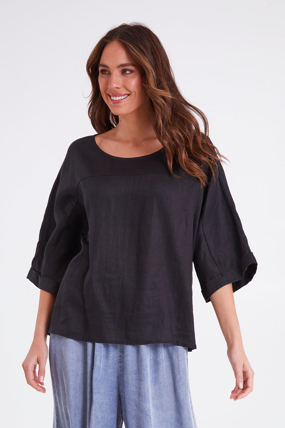 Model Madeline wearing size OneSize of the Studio Relaxed Top in colour Ebony (Black), from the front, cropped image