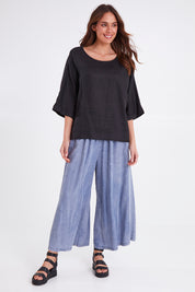 Model Madeline wearing size OneSize of the Studio Relaxed Top in colour Ebony (Black), from the front, showing the whole outfit