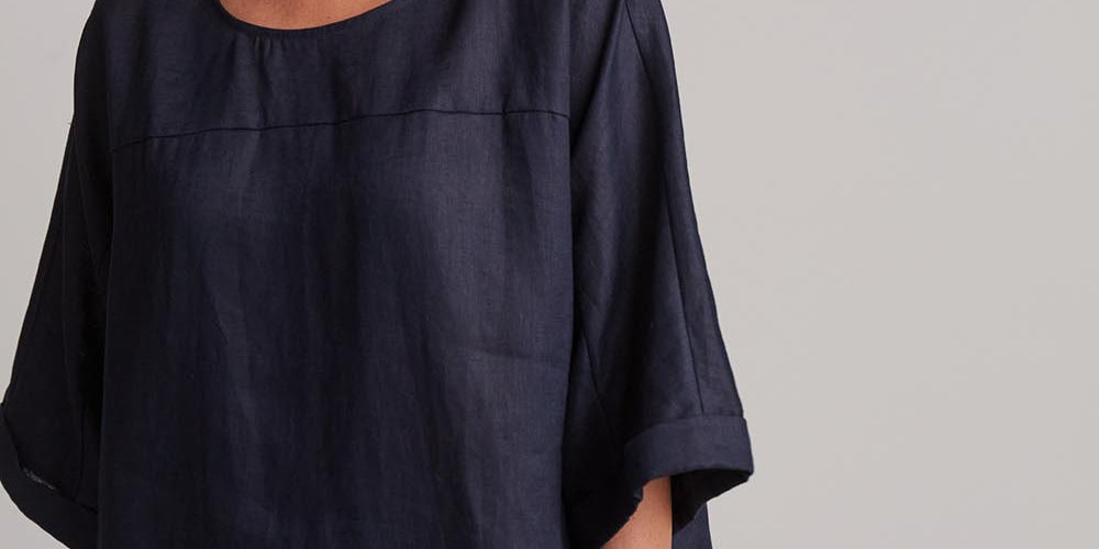 A model wearing the Studio Relaxed Top in colour Navy (Blue), from the front, cropped image