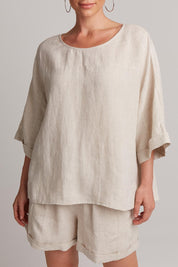 A model wearing the Studio Relaxed Top in colour Tusk, from the front, cropped image