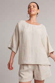 A model wearing the Studio Relaxed Top in colour Tusk, from the front, cropped image