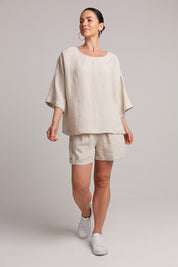 A model wearing the Studio Relaxed Top in colour Tusk, from the front, showing the whole outfit