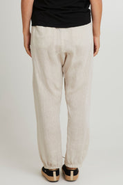 Model Katie wearing size S of the Studio Relaxed Linen Pant in colour Tusk, from the back