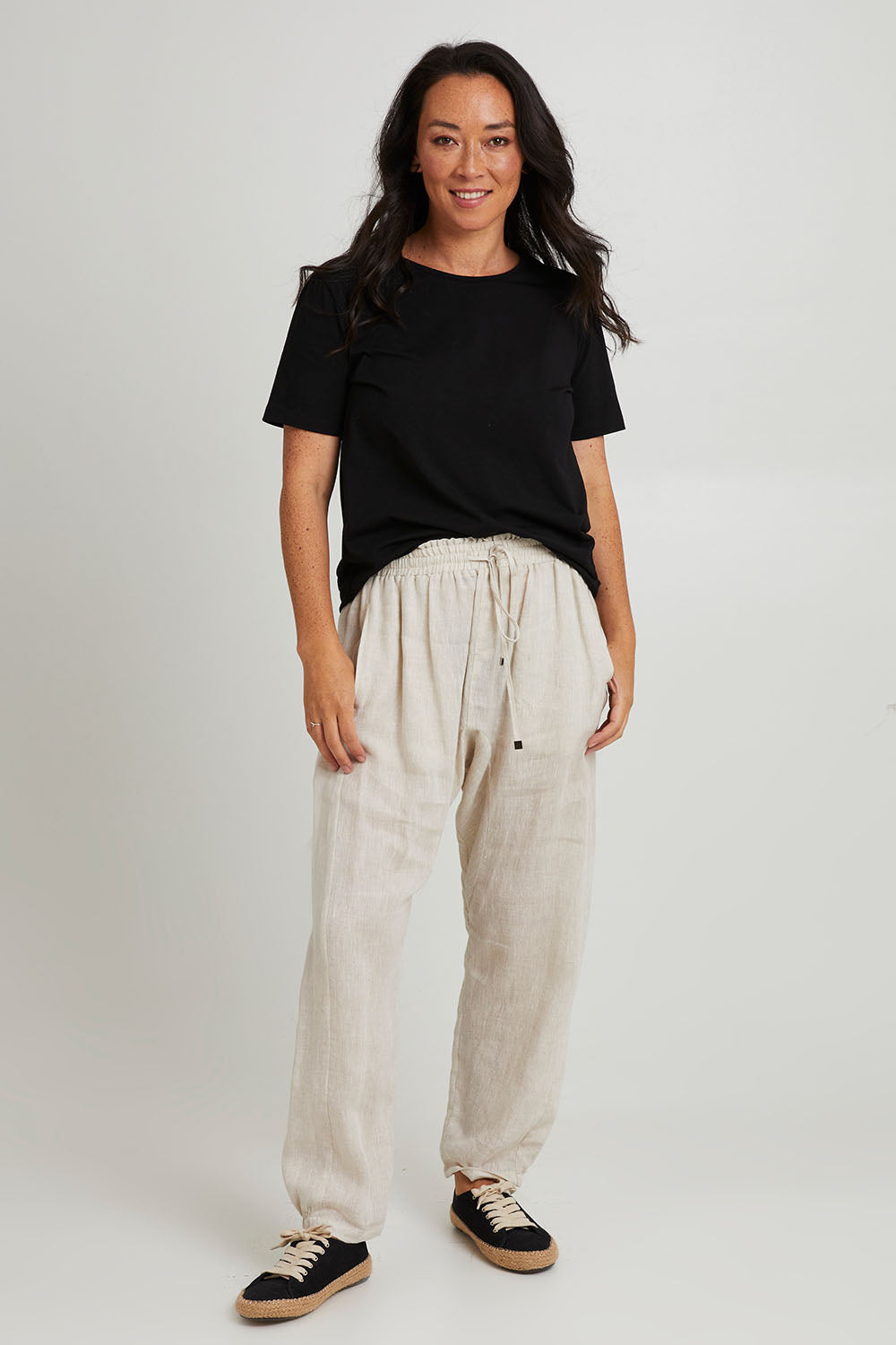 Model Katie wearing size S of the Studio Relaxed Linen Pant in colour Tusk, from the front, showing the whole outfit
