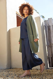 A model wearing the Studio Crop Pant in colour Navy (Blue), from the front, showing the whole outfit