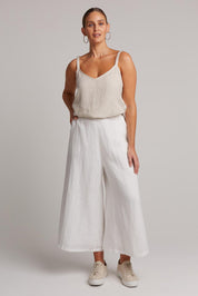 A model wearing the Studio Crop Pant in colour Salt (White), from the front, showing the whole outfit