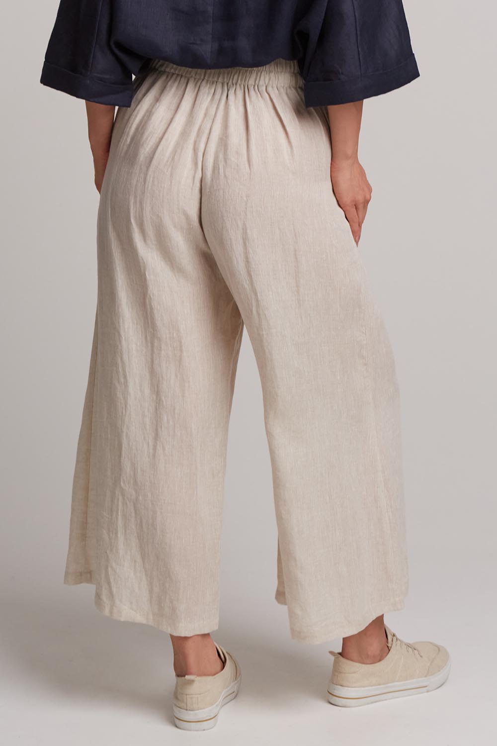 A model wearing the Studio Crop Pant in colour Tusk, from the back