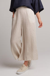 A model wearing the Studio Crop Pant in colour Tusk, from the front, cropped image