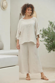 A model wearing the Studio Crop Pant in colour Tusk, from the front, showing the whole outfit
