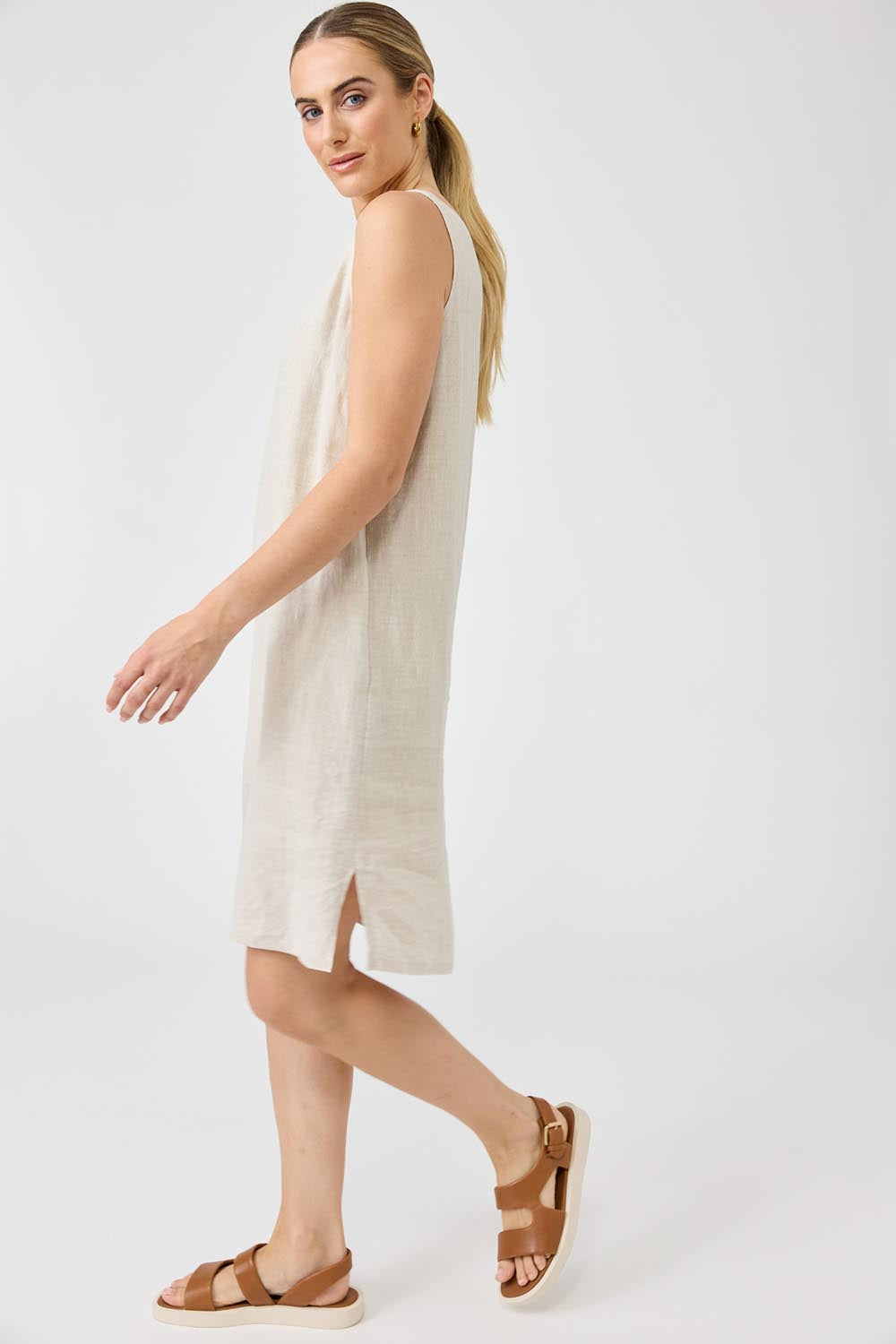 A model wearing the Studio Linen Midi Dress in colour Tusk, from the front, showing the whole outfit