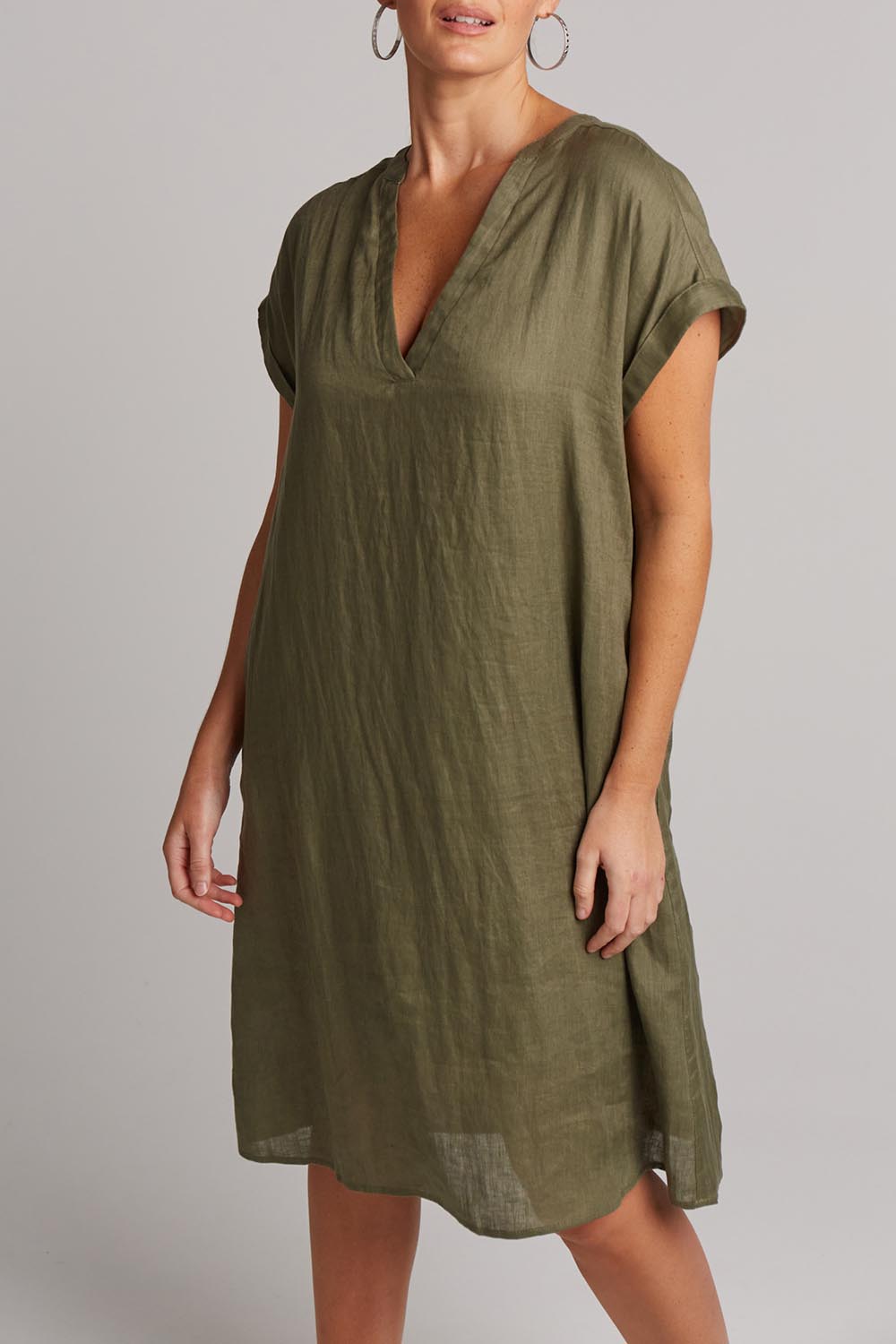 A model wearing the Studio Linen Dress in colour Khaki (Green), from the front, cropped image