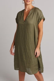 A model wearing the Studio Linen Dress in colour Khaki (Green), from the front, cropped image