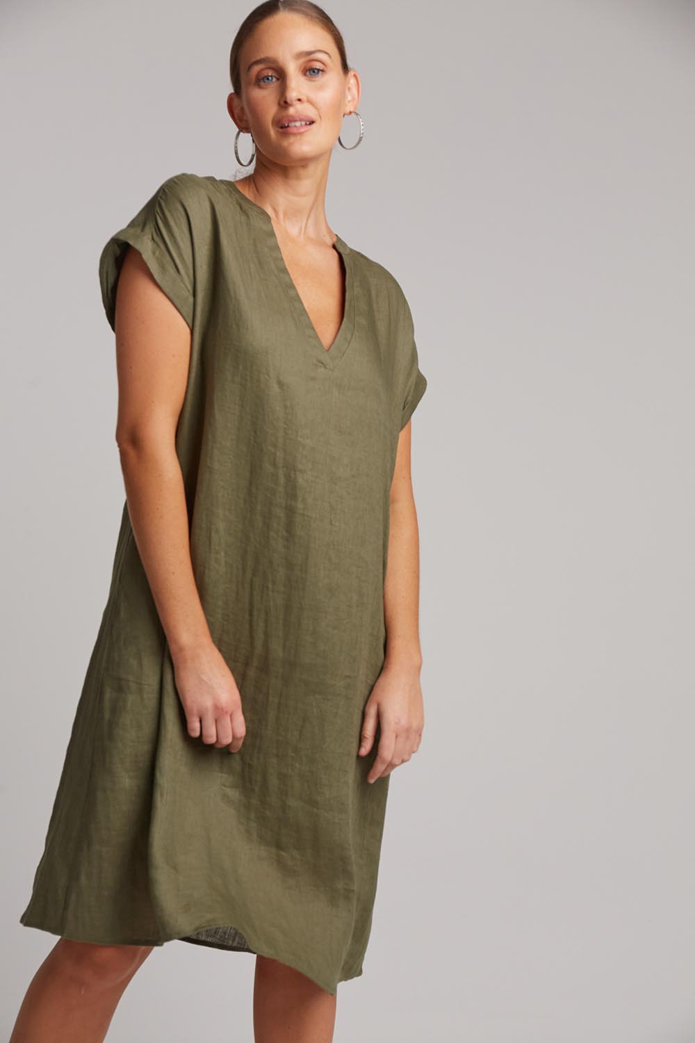 A model wearing the Studio Linen Dress in colour Khaki (Green), from the front, cropped image