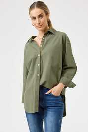 A model wearing the Studio Oversize Cotton Shirt in colour Khaki (Green), from the front, cropped image