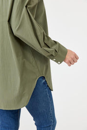A model wearing the Studio Oversize Cotton Shirt in colour Khaki (Green), from the front, cropped image