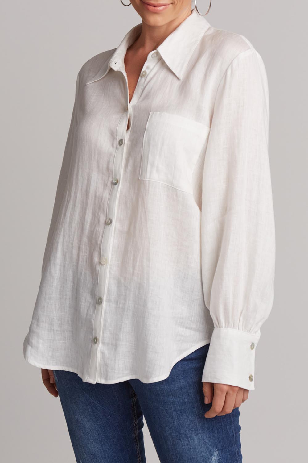 A model wearing the Studio Linen Shirt in colour Salt (White), from the front, cropped image