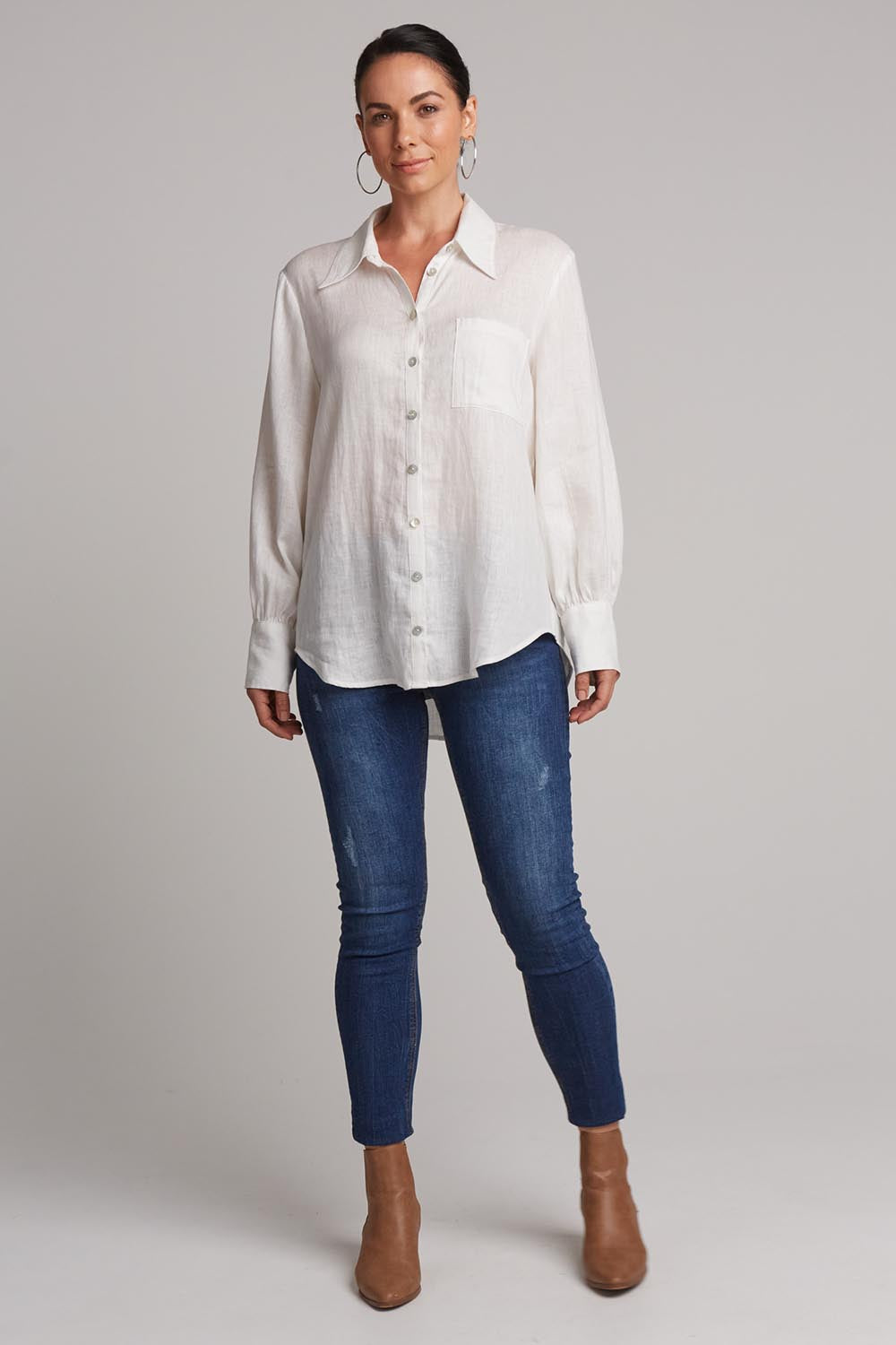 A model wearing the Studio Linen Shirt in colour Salt (White), from the front, showing the whole outfit