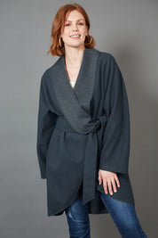 A model wearing the Klein Wrap Jacket in colour Oxford (Blue), from the front, showing the whole outfit