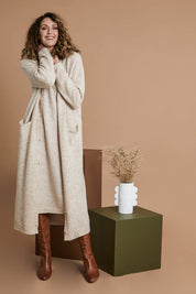 Model Emma wearing size OneSize of the Kinsella Cardigan in colour Tusk, from the front, showing the whole outfit